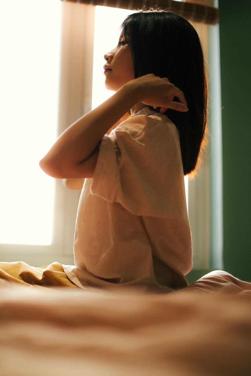 Woman enjoying peaceful morning light while preparing for the day